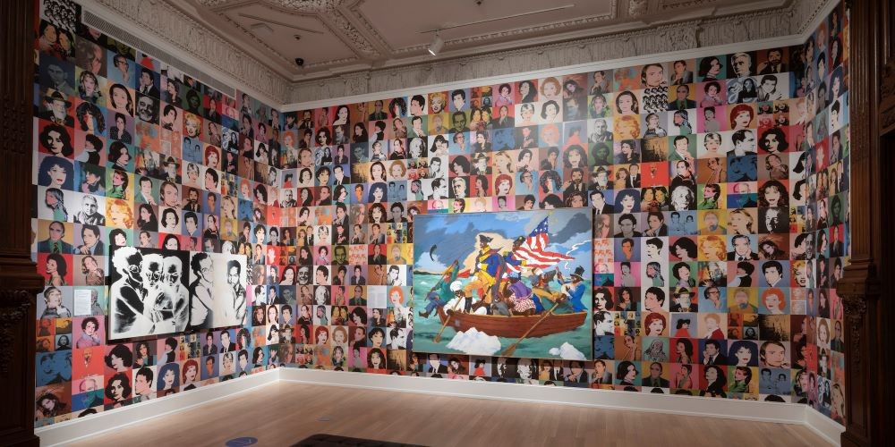 Visual art exhibit of portraits lining the walls of a room