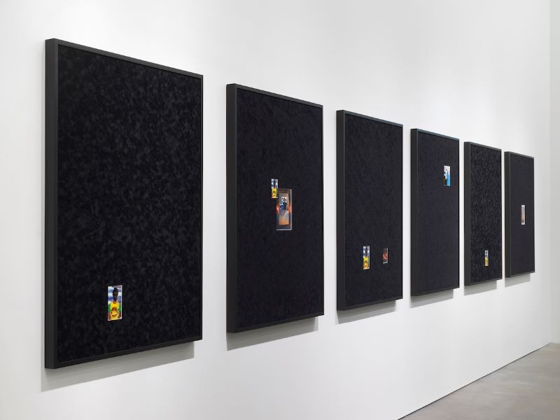 'Grief & Grievance: Art and Mourning in America' small photographs on large black canvas in a gallery