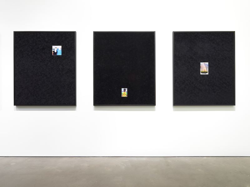 'Grief & Grievance: Art and Mourning in America' small photographs on large black canvas in a gallery