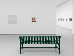 bench in front of white wall with picture