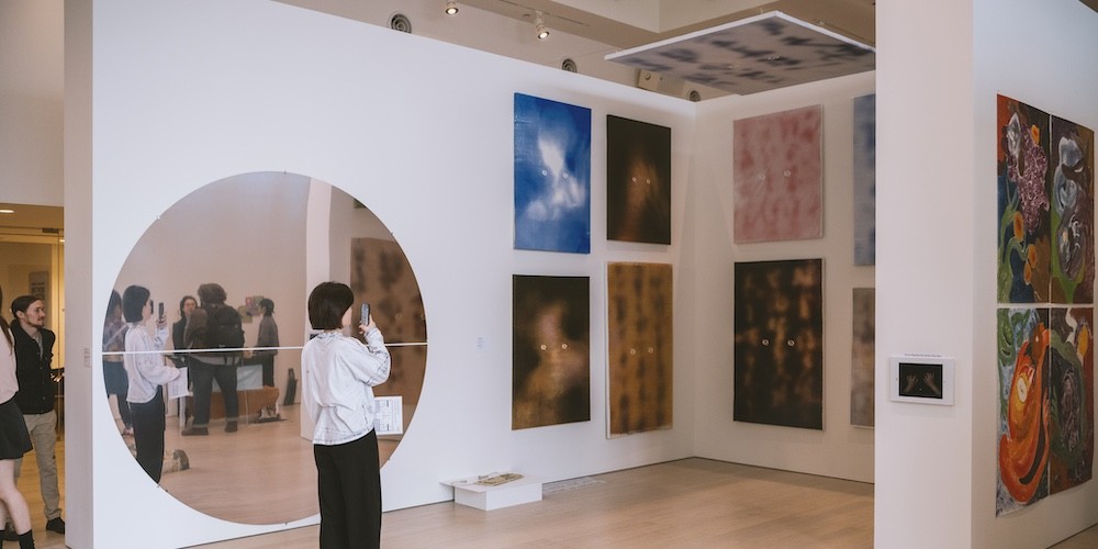 People observe artwork in a gallery. 