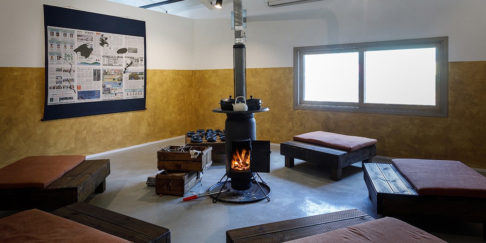 Visitors sit around the wood-fire stove and are served tea, makgeolli, and green curry on Jeju Onggi (ceramicware) created in collaboration between Professor Rirkrit Tiravanija and local Jeju ceramicist Kang Seung-chul