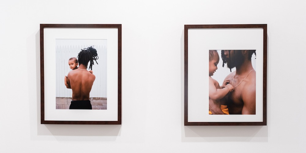 Two framed photographs of a man and a baby. 