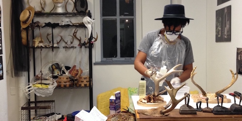 Artist in studio working with antlers