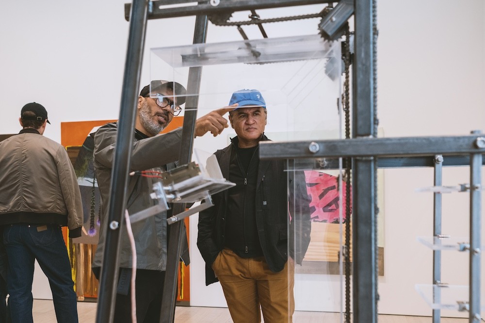 People explore artwork in gallery.