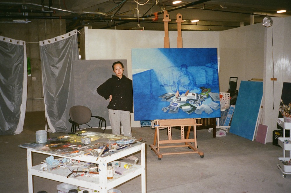 Artist stands in studio. 