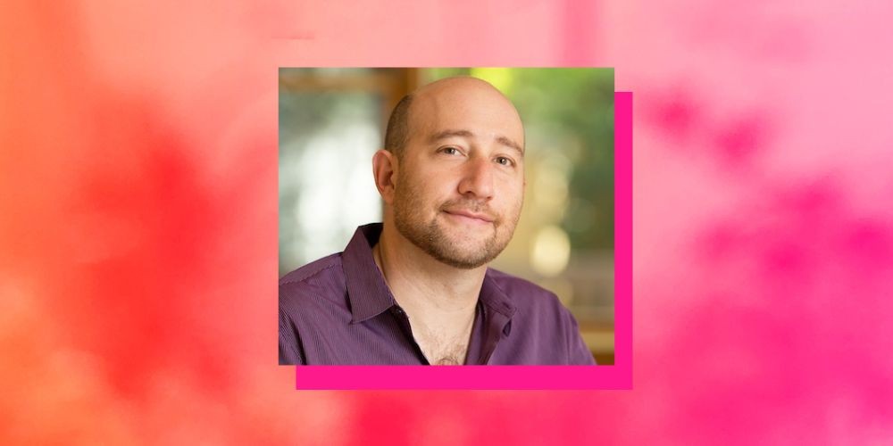 Headshot of Aaron Hamburger on a pink background