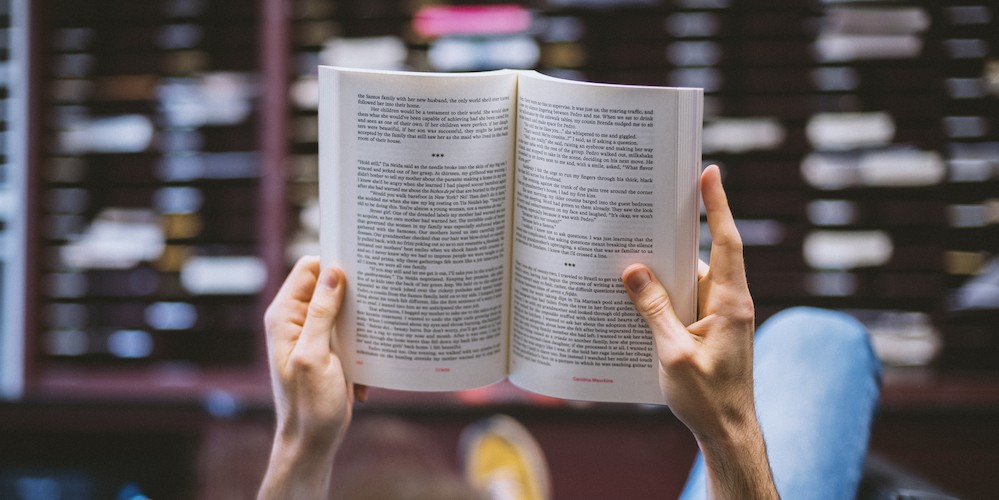 Close up of two hands holding an open book