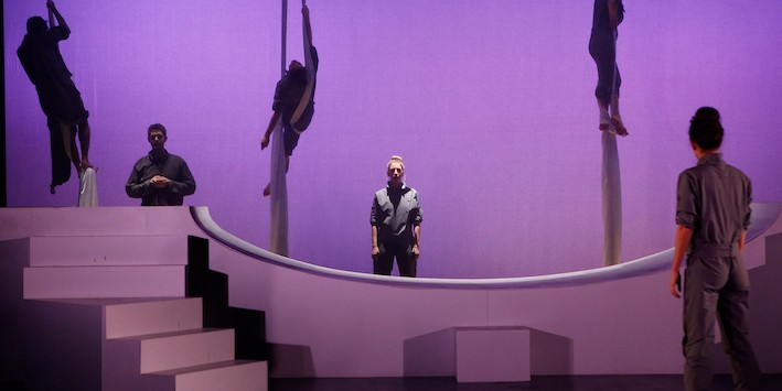 Actors on a purple hued stage