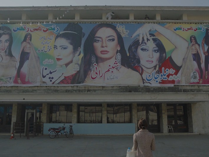 A woman looking at a billboard of other women
