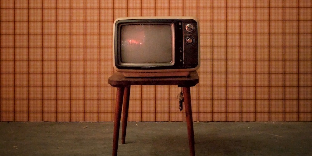 a vintage tv against an orange background