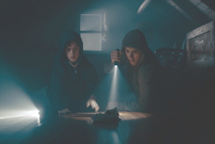 Boys searching a dark space with a flashlight 