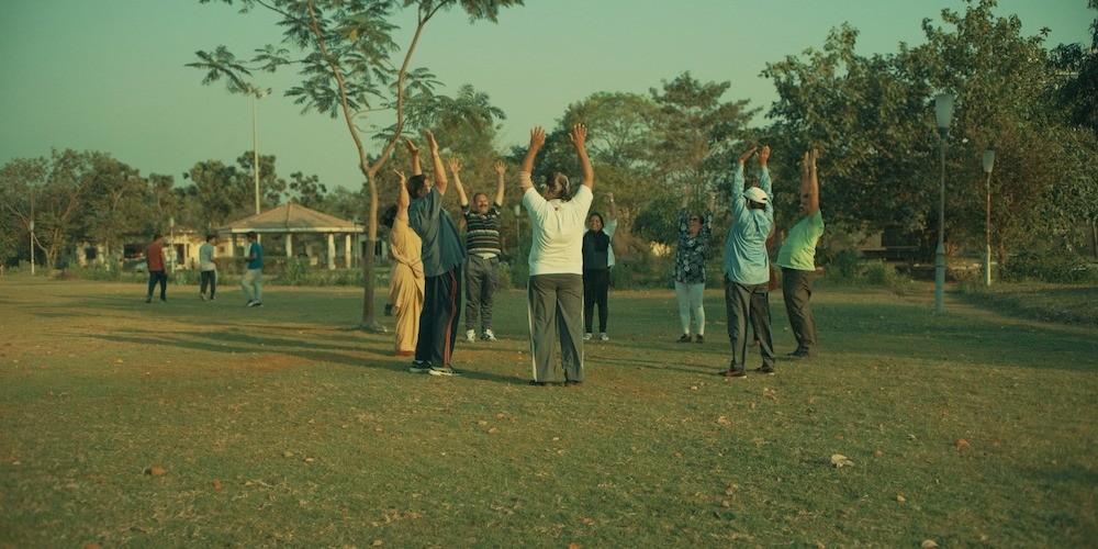 Middle Aged South Asians hanging out in a circle, happily stretching
