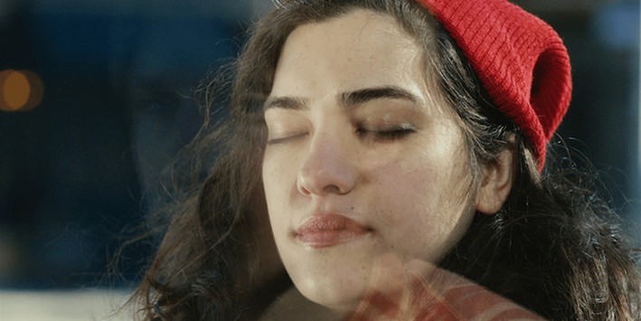 A woman in a red hat with closed eyes