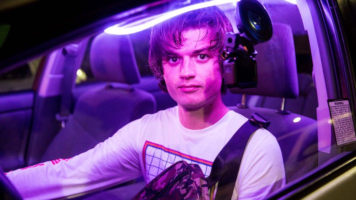 A man in a car with purple lights.
