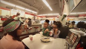 a scene in a diner with young women of color
