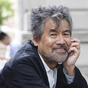 Asian man with long salt and pepper hair smiling