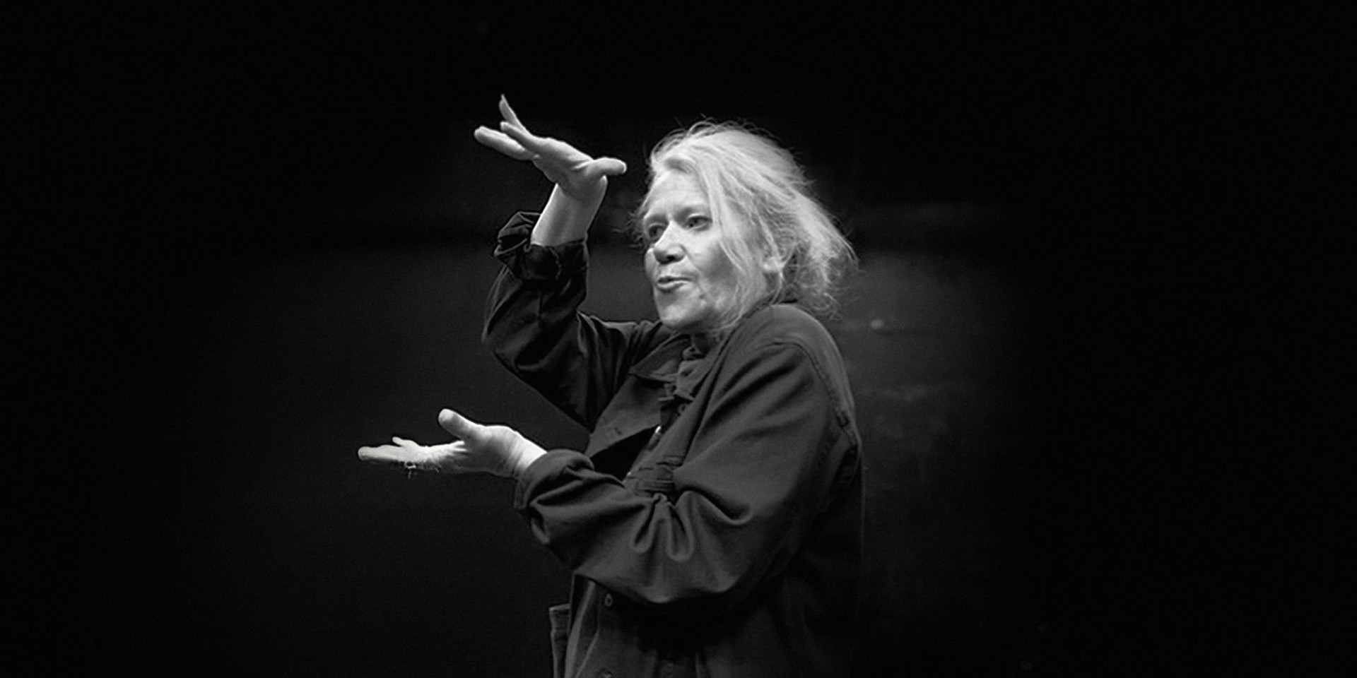 Black and white photo of Morgan Jenness gesturing with their hands. 