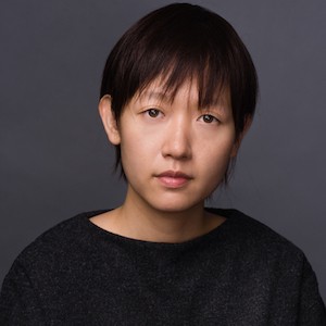 Asian woman with short hair and a black shirt.