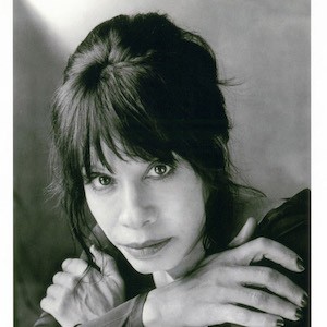 Black and white portrait of a woman with dark hair arms folded